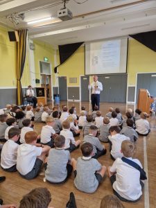 Young students listening to a teacher in a classroom setting.