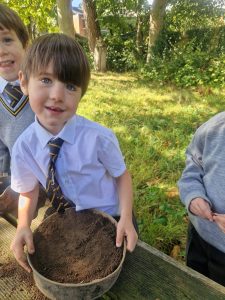 Children planting outdoors at Inchmarlo for community learning.