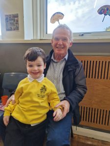 Smiling boy in school uniform with adult, highlighting Inchmarlo's educational environment.