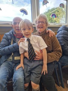 Happy family with young boy and grandparents at Inchmarlo community event.
