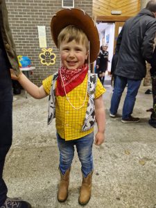 Young boy dressed as a cowboy at Inchmarlo estate event, smiling and enjoying outdoor activities.