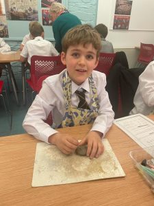 Young boy crafting in school classroom, engaging in hands-on activity.