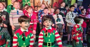 Children dressed in colorful Christmas sweaters at Inchmarlo event.
