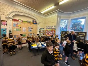 Bright classroom scene with kids in uniform and teacher engaging students in learning.