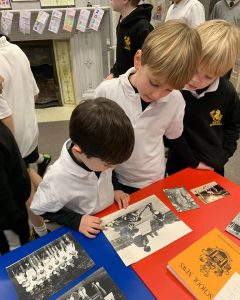 Children exploring historical photos at Inchmarlo school.