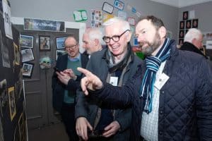 People viewing and discussing artwork at Inchmarlo art exhibition.