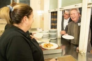 Friendly staff serving meals at Inchmarlo care home.