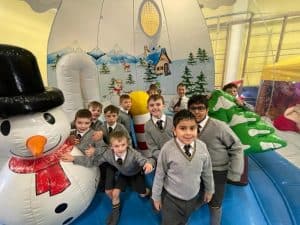 Children enjoying festive inflatable attraction at Inchmarlo holiday park.