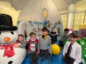 Children playing at Inchmarlo indoor activity space featuring snowman and inflatable games.
