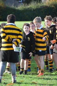 Children playing rugby at Inchmarlo, outdoor sports education in a scenic setting.