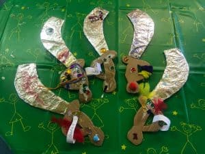 Colorful handmade rocket Christmas decorations on green craft paper. Perfect for holiday celebrations and festive decor.