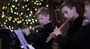 Young children playing flutes at Inchmarlo holiday event.