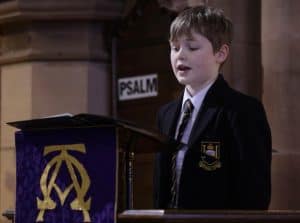 Young boy reading at Inchmarlo school, emphasizing education and community.