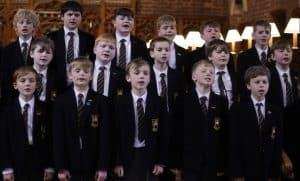 Group of boys singing in school uniform at Inchmarlo school event.