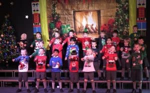 Children singing Christmas carols at Inchmarlo festive event, showcasing holiday spirit and community celebration.