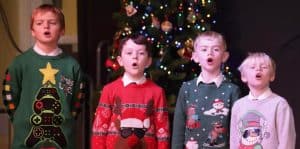 Cheerful children singing Christmas carols at Inchmarlo estate.