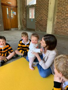 Young children playing with caregiver at Inchmarlo childcare facility in Scotland.