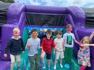 Children enjoying a colorful bounce house at Inchmarlo outdoor event.