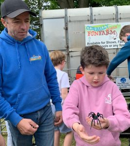 Child holding a spider at Inchmarlo forest park, exploring nature and outdoor activities in Aberdeenshire.