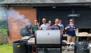 Outdoor BBQ grill with people enjoying themselves.