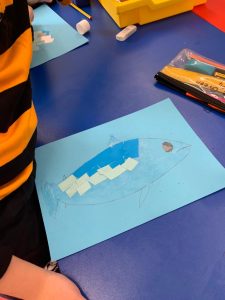 Creative school project with paper models on blue paper.