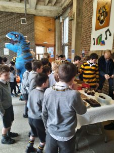 Children enjoying a fun event at Inchmarlo surrounded by a friendly dinosaur mascot.