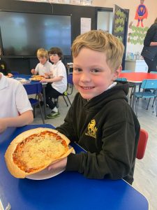 Happy boy with pizza at Inchmarlo school event.