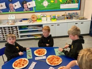 Children enjoying pizza lunch at Inchmarlo nursery.