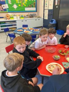 Young children enjoying a meal at a colorful school dining table.