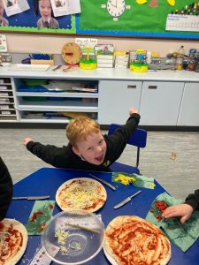 Happy children enjoying pizza at Inchmarlo childcare.