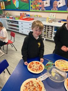 Young boy enjoying pizza at Inchmarlo school.