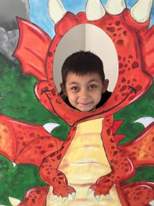 Child enjoying a dragon-themed photo at Inchmarlo.