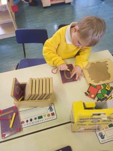 Young child playing with educational toys at Inchmarlo childcare center.