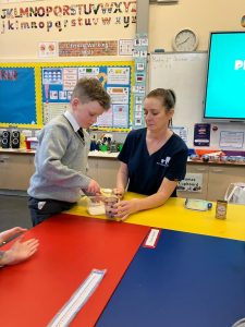Young student receiving hands-on activity from teacher in classroom setting.