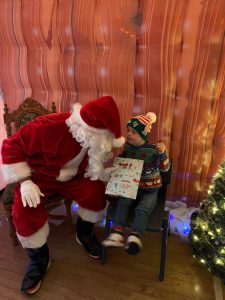 Santa Claus with child in festive setting at Inchmarlo.