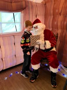 Boy meets Santa at Inchmarlo House, celebrating festive traditions in a cozy, welcoming holiday setting.