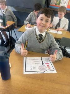 Young student smiling with schoolwork at Inchmarlo school.