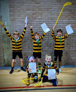 Children celebrating with certificates in school sports event.