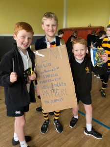 Happy children holding a sign at Inchmarlo School in Scotland.
