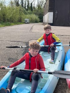 Two kids enjoying a kayak adventure outdoors at Inchmarlo estate in Scotland.