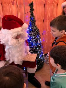 Children meeting Santa at Inchmarlo Christmas event, festive atmosphere and holiday joy.