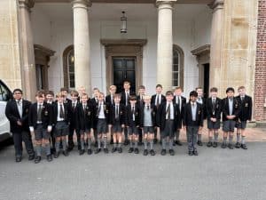 Group of students in formal uniforms standing in front of Inchmarlo estate.