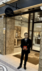 Young guest holding a red jewelry box at Inchmarlo hotel entrance in a formal evening attire.
