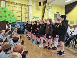 Young students performing in school assembly at Inchmarlo School, showcasing engaging educational activities.