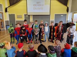 Children in colorful costumes and superheroes during a school event at Inchmarlo.