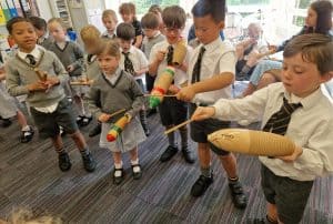 Young students playing traditional instruments during school activity.