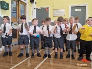 Children playing musical instruments in classroom setting.