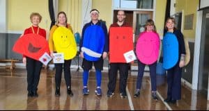 Group of people holding colorful heart-shaped signs at Inchmarlo Nursing Home.