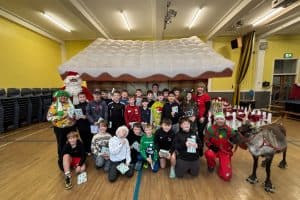 Group of children and adults celebrating Christmas at Inchmarlo with festive decorations and Santa Claus.