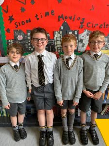 Group of four smiling students in school uniform at Inchmarlo Primary School, showcasing education and community.